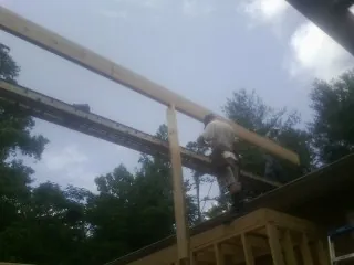 Carpenter setting a ridge beam over a new addition frame — Ice Dam Removal by Roofing Brothers in White Salmon