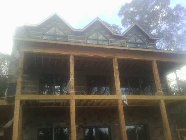 Dormers and porch framing on a large log home under construction — Roof Coating work by our crew in White Salmon