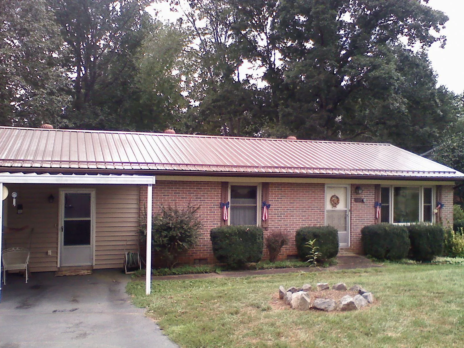 Bronze metal roof and carport on a brick ranch home — Roof Repair work by our crew in White Salmon